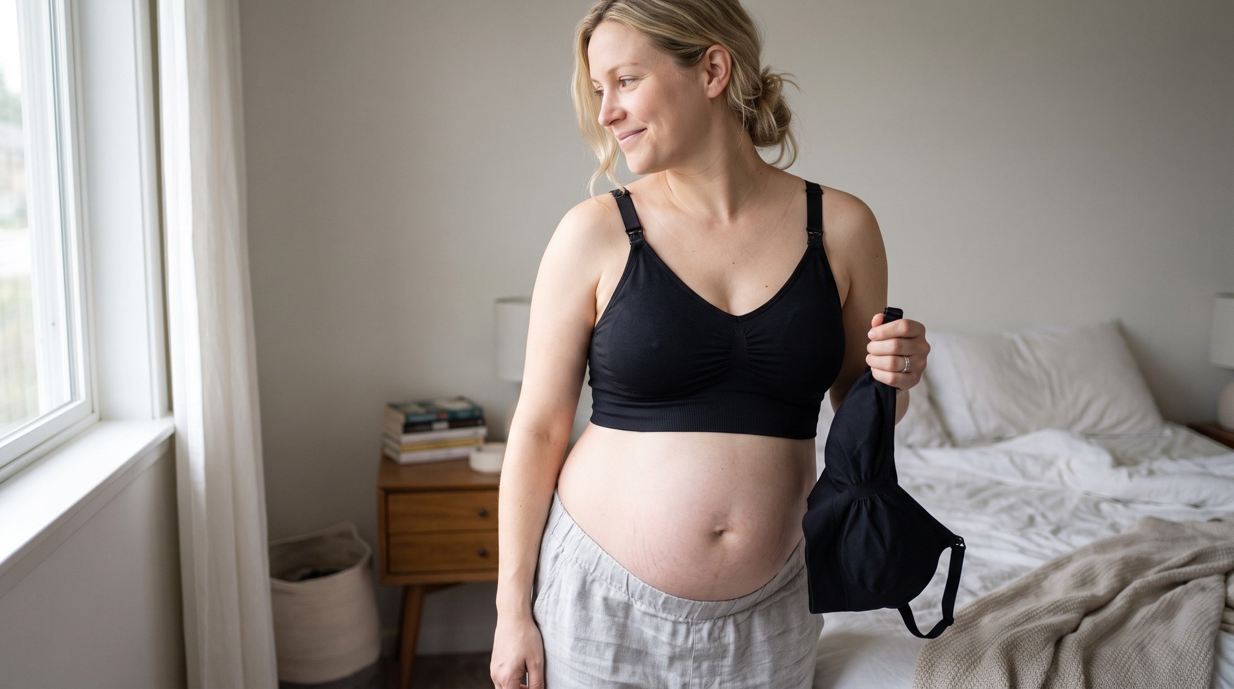A mother in a bedroom holding a nursing bra